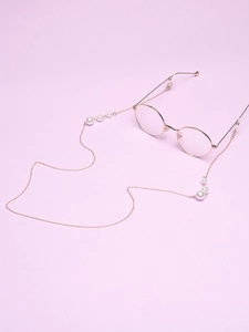Detail of rose gold round metal glasses with an elegant white pearl eyewear chain