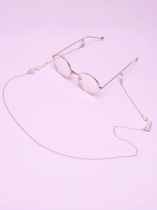 Detail of elegant gold eyewear chain with white pearls on a soft purple background