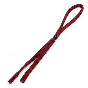 Detail of red and black woven eyeglass cord with a black bead on a white background