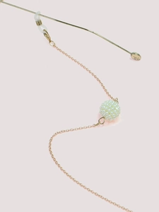 Detail of gold metal eyewear chain with white pearl ball and transparent rubber loop hooks