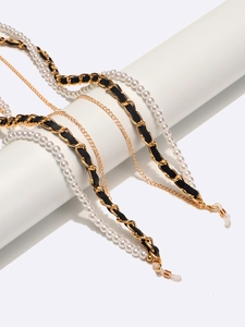 Detail of multi-layer eyeglass chain with pearls, gold links, and black leather strap