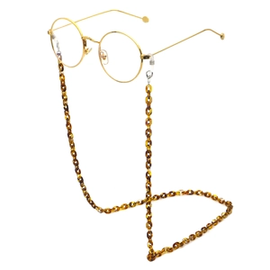 Detail of amber tortoiseshell acrylic eyewear chain with gold frame and silicone loops