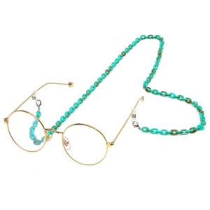 Round gold metal glasses with turquoise acrylic eyewear chain on white background