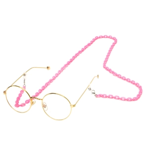 Close-up of pink resin chain strap on vintage gold frame round glasses
