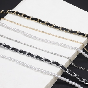 Detail showing assorted metal chain straps with leather weaving and pearl bead accents