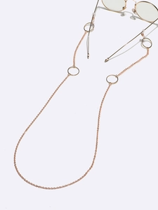 Detail of gold metal eyewear chain with decorative large rings and silicone loops
