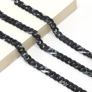 Macro view of black and white marble pattern acrylic eyeglass chain links on white book