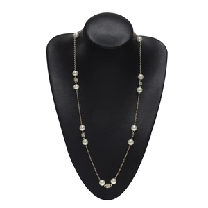 Elegant gold pearl necklace with rhinestone accents on a black jewelry display stand