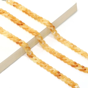 Close-up of amber acrylic eyeglass chain showing interlocking link details and texture