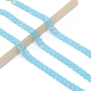 Macro shot of light blue acrylic Cuban link chain over a wooden bar on white background