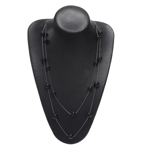 Double-layer gold chain necklace with black pearls displayed on a jewelry bust stand