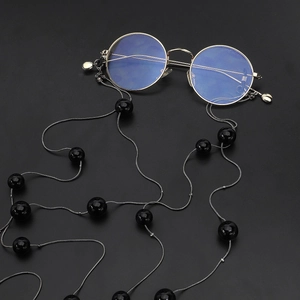 Gold round frame glasses with black beaded double-layer chain on black background