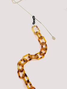 Detailed macro view of amber leopard print acrylic eyeglass chain with rubber loops