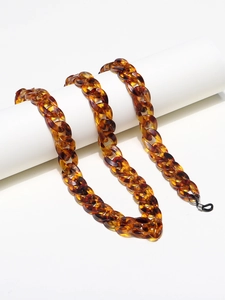 Close-up of leopard resin eyeglass chain with bold links and black rubber loops