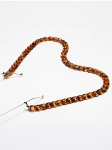 Detail of amber tortoiseshell acrylic eyewear chain with black rubber connectors