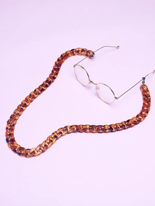 Detail of retro tortoiseshell acrylic eyewear chain with large links and gold frames