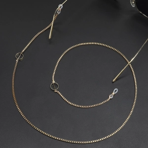 Golden sun glasses chain with minimalist metal ring decor on black matte surface