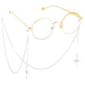 Close-up of golden round frame glasses with silver chain featuring star pendants