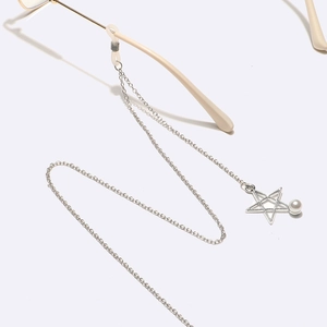 Detail of silver eyewear chain featuring star pendant and pearl on white temple arm