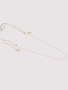 Detail showing gold eyeglass chain with hollow star pendants and small white pearls