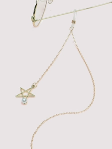 Detail of gold metal eyewear chain with hollow star pendant and white pearl charm