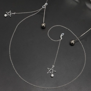 Silver eyewear chain featuring metal star pendants and elegant white pearls on a dark background