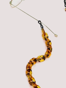 Détail de la chaîne de lunettes en résine léopard avec maillons en acrylique ambré