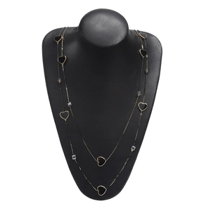 Double-layer gold necklace with black heart charms and crystals on a black display bust