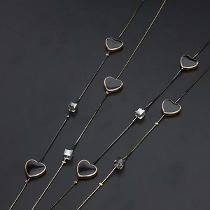 Double-layered gold chain sweater necklace with black heart and clear crystal accents