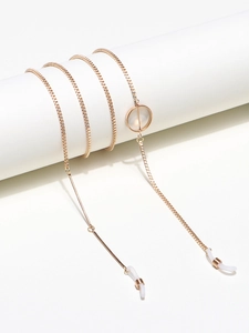 Macro detail of golden box chain eyewear holder with silicone anti-slip loop and gold coil