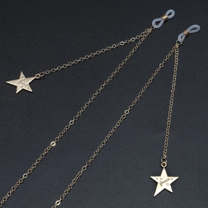 Golden star eyeglass chain with 'forever' engraved charms on black textured background