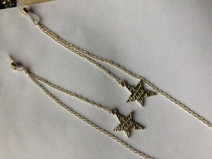 Detail of gold star eyewear chain with engraved charms and silicone non-slip loops