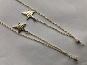 Detail of gold star eyewear chain with textured pendants and silicone anti-slip loops