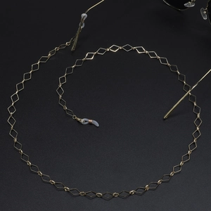 Golden geometric diamond chain for glasses with non-slip silicone loops on black background