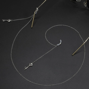 Silver metal glasses chain featuring punk skull and heart key charms on black background