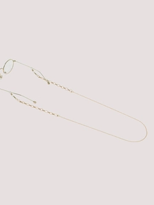 Detail of golden non-slip eyewear chain with geometric hollow patterns and rubber loops