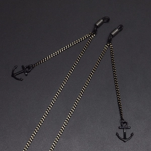 Minimalist black glasses chain with anchor pendants and rubber loops on grey background