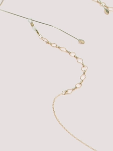 Close-up of golden geometric glasses chain with rhombic links and silicone loops