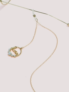 Détail de la chaîne de lunettes dorée avec pendentif LOVE, perles et attaches