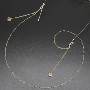 Chaîne de lunettes dorée avec pendentifs en zircon en forme de cœur sur fond noir