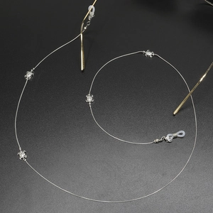 Silver eyewear chain with turtle pendants and anti-slip rings on a black background