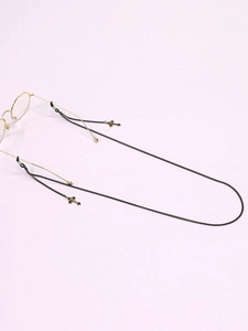 Detail of black metal eyewear chain featuring two cross pendants and adjustable rubber loops