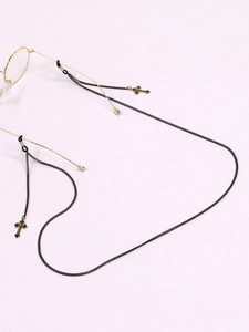 Close-up of black metal eyewear chain featuring fashionable cross pendants and rubber loops