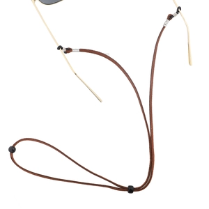 Détail du cordon à lunettes marron avec ressorts argentés et boucles en caoutchouc noir
