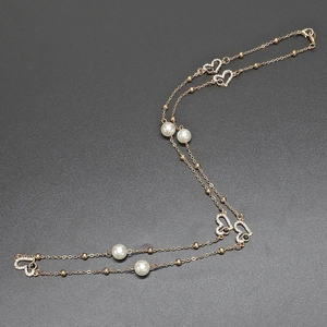 Collana lunga e catena per occhiali dorata con perle, strass e ciondoli a cuore vuoto