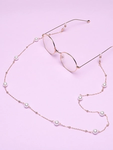 Detail of rose gold pearl glasses chain with adjustable silicone loops on purple background