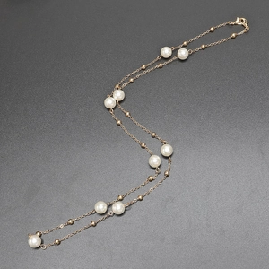Elegant gold layered pearl necklace featuring white pearls on a fine metal chain with clasp