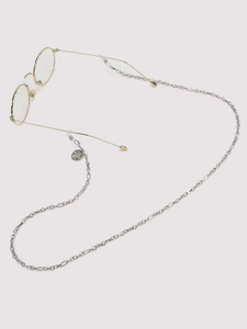 Detail of silver Figaro chain eyewear strap with tree of life pendant on glasses