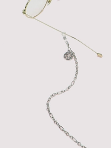 Detail of silver tree of life charm and silicone loops on the metal glasses chain