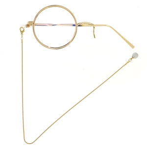 Retro golden monocle with a sleek snake chain and white pearl bead on a white background